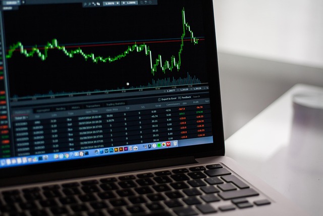 trading education FAQ page with market charts and notes on a laptop screen